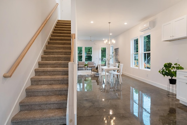 staircase featuring baseboards, an AC wall unit, a notable chandelier, and recessed lighting