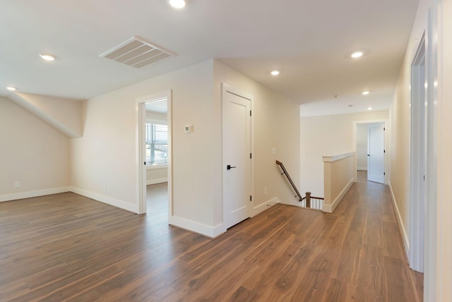 hallway featuring baseboards, visible vents, wood finished floors, an upstairs landing, and recessed lighting