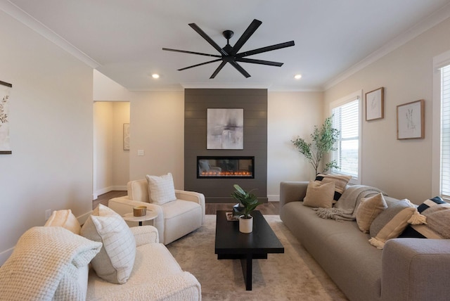 living room with a large fireplace, baseboards, a ceiling fan, ornamental molding, and recessed lighting