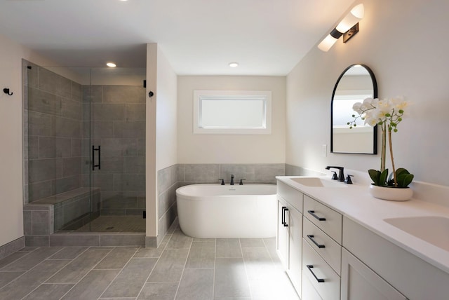 bathroom with a sink, a soaking tub, tile patterned floors, double vanity, and a stall shower