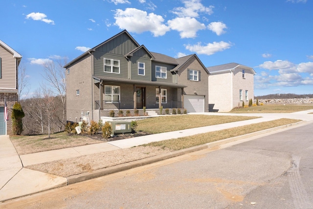 view of front facade featuring a garage, covered porch, driveway, and board and batten siding