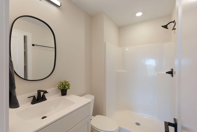 bathroom featuring recessed lighting, a shower stall, toilet, and vanity