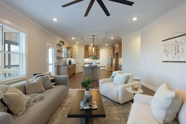 living area with recessed lighting, baseboards, crown molding, and wood finished floors