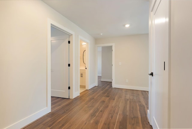 corridor with baseboards and dark wood finished floors