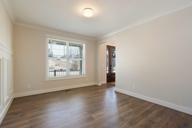 unfurnished room with ornamental molding, dark wood-type flooring, visible vents, and baseboards