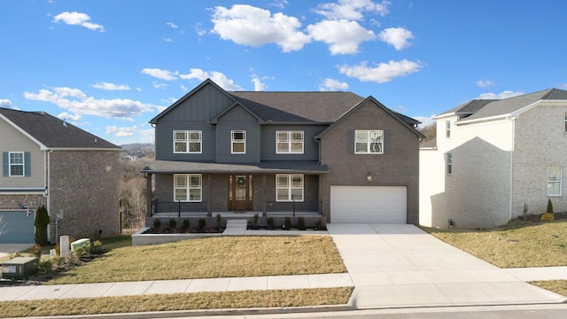 view of front facade with an attached garage, covered porch, concrete driveway, a front lawn, and board and batten siding