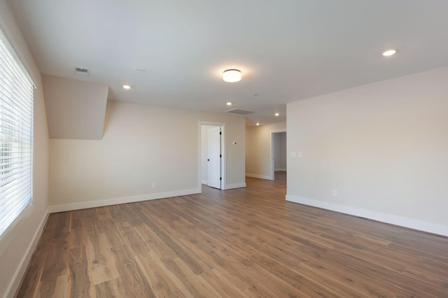 spare room with baseboards, wood finished floors, and recessed lighting