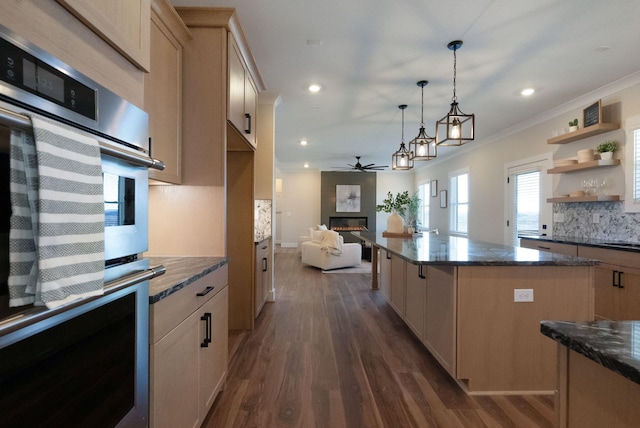 kitchen featuring dark wood-style floors, a fireplace, tasteful backsplash, double oven, and ornamental molding