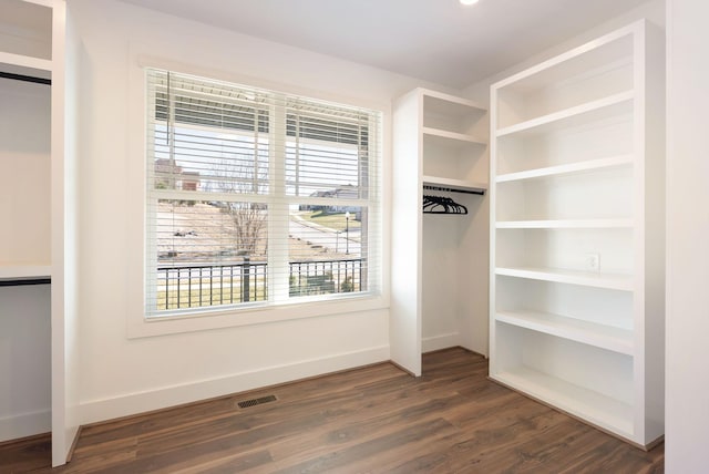 spacious closet with dark wood-style floors and visible vents