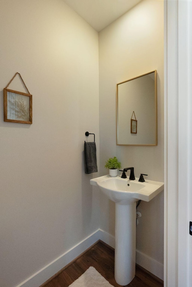 bathroom with wood finished floors and baseboards