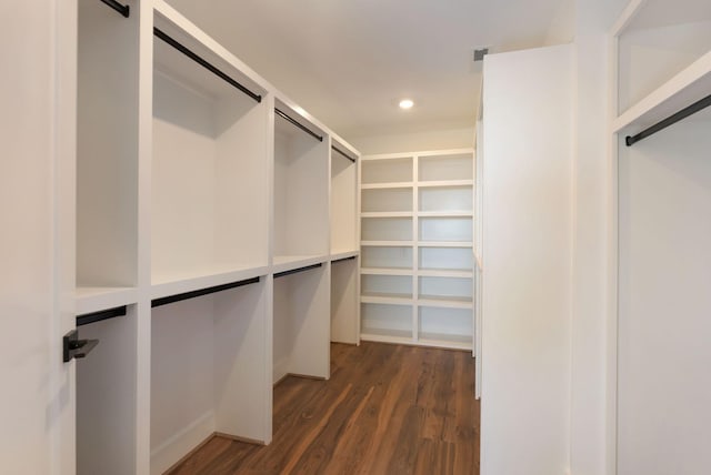 walk in closet featuring a barn door, visible vents, and dark wood finished floors