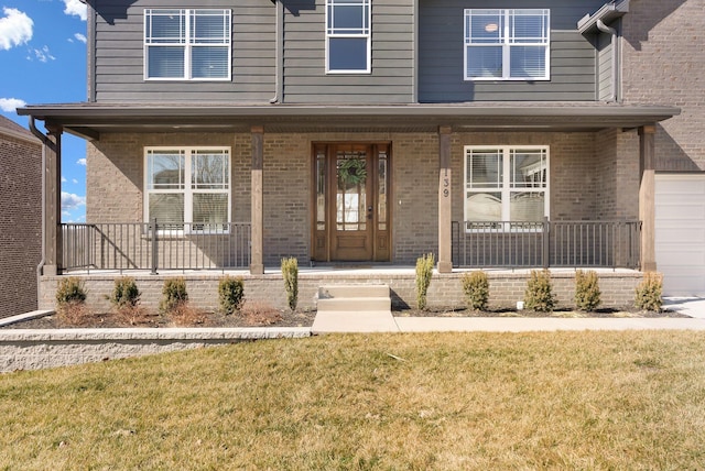 view of front of home featuring a front yard, covered porch, and brick siding