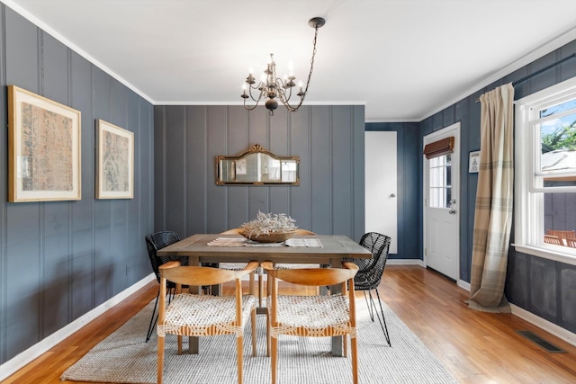 dining space with light wood-style floors, visible vents, a notable chandelier, and baseboards