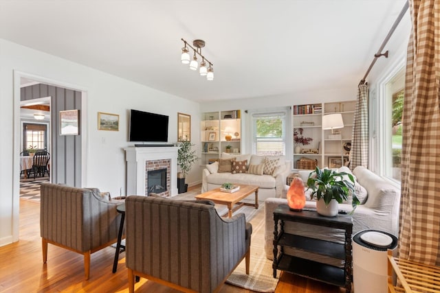 living room featuring a brick fireplace and light wood-style flooring