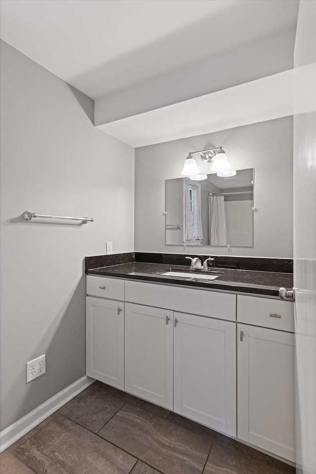 bathroom featuring curtained shower, baseboards, and vanity