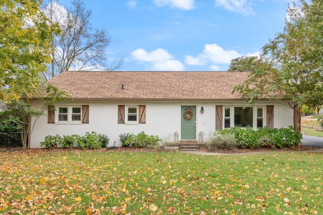 single story home with a front yard, roof with shingles, and brick siding