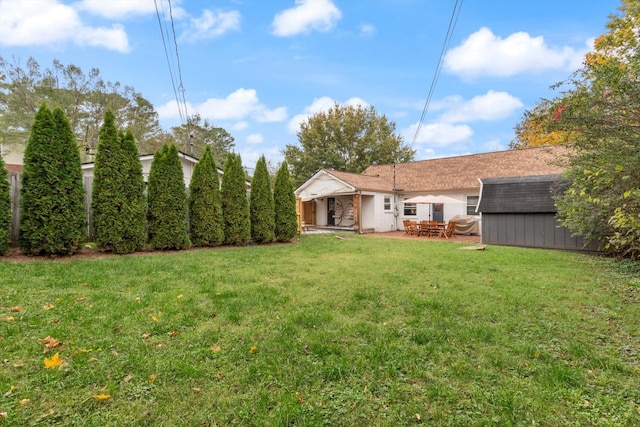 view of yard featuring an outdoor structure, a patio, and a shed