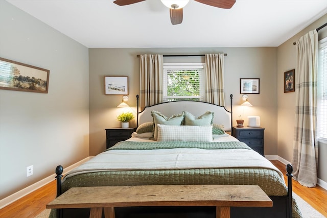 bedroom featuring ceiling fan, light wood-style flooring, and baseboards