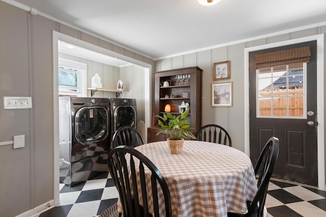 dining area featuring crown molding, independent washer and dryer, a decorative wall, and tile patterned floors