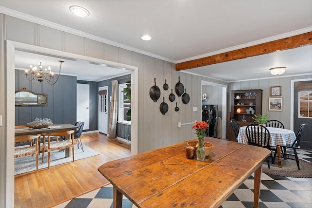 dining room with ornamental molding, a notable chandelier, light wood-style floors, and separate washer and dryer