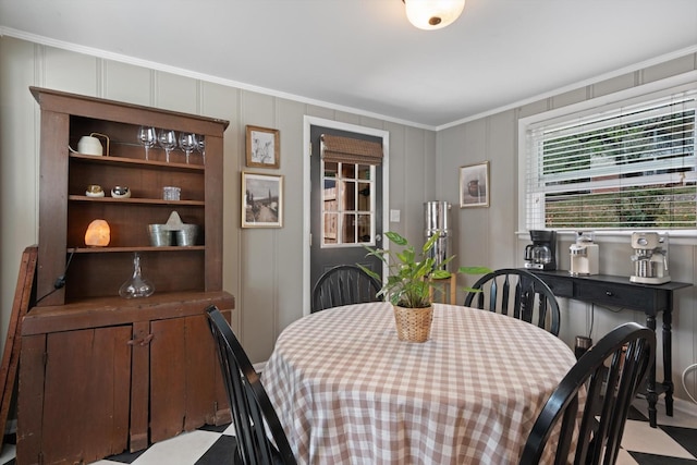 dining room featuring ornamental molding and a decorative wall