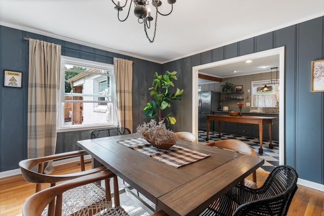 dining area with ornamental molding, baseboards, and wood finished floors