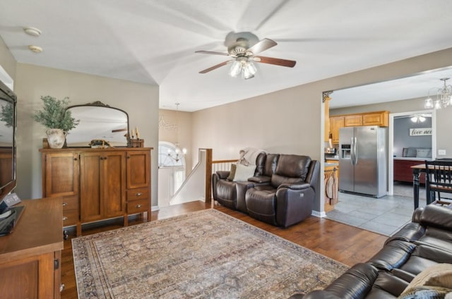 living area featuring ceiling fan with notable chandelier and light wood-style floors
