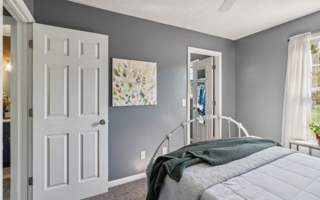carpeted bedroom featuring baseboards and ceiling fan