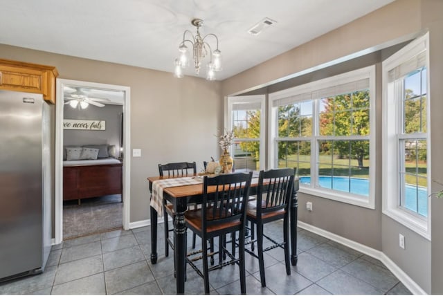 tiled dining area featuring a wealth of natural light, visible vents, and baseboards
