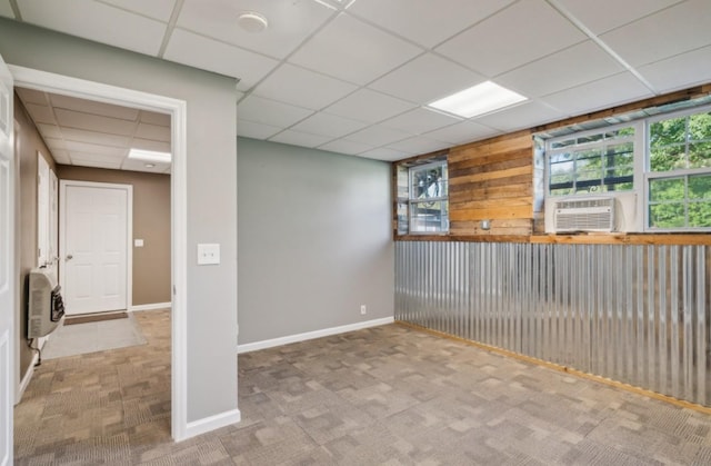 interior space featuring baseboards, carpet flooring, cooling unit, heating unit, and a paneled ceiling