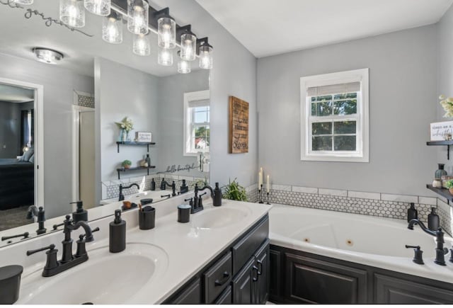 bathroom with a sink, double vanity, and a whirlpool tub