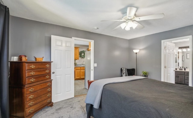 bedroom featuring light carpet, a ceiling fan, and ensuite bathroom