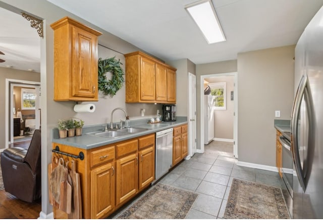 kitchen featuring tile patterned floors, a healthy amount of sunlight, appliances with stainless steel finishes, and a sink