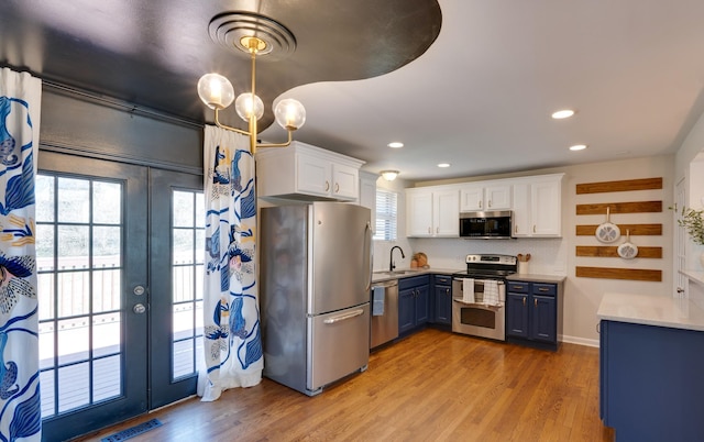 kitchen with stainless steel appliances, a sink, visible vents, and white cabinetry