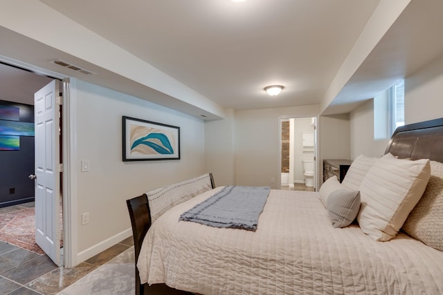 bedroom with ensuite bathroom, visible vents, and baseboards