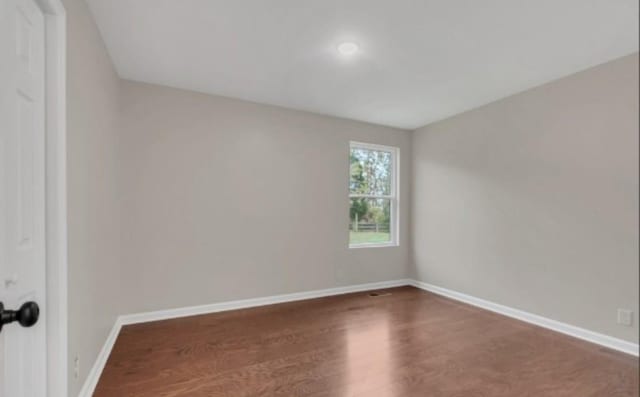 unfurnished room featuring wood finished floors and baseboards