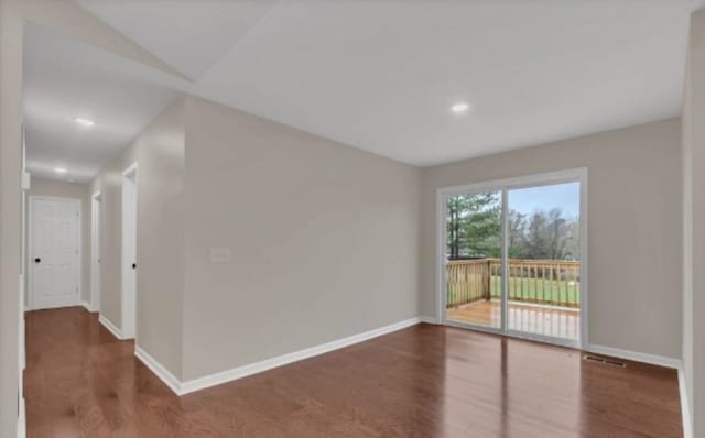 empty room with visible vents, baseboards, and wood finished floors