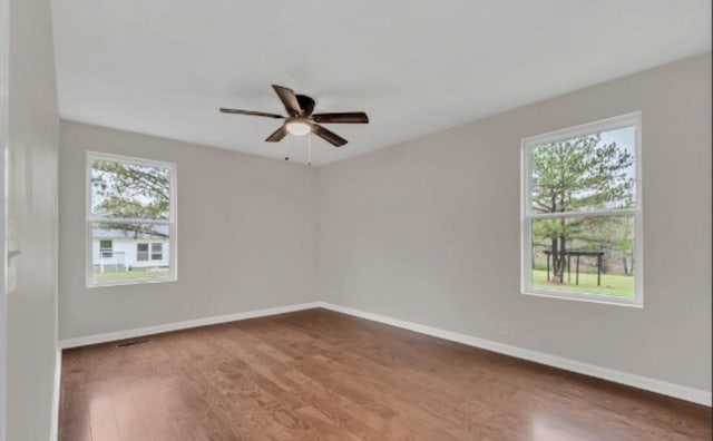 spare room with ceiling fan, wood finished floors, and baseboards