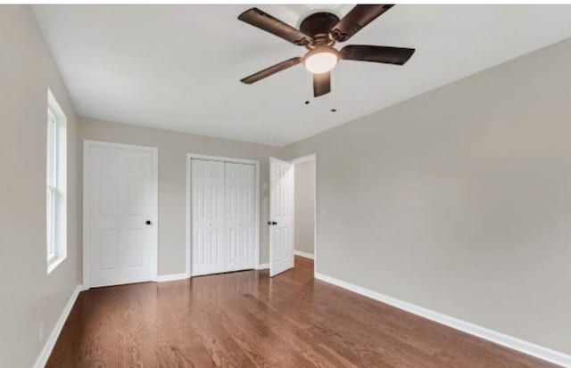 unfurnished bedroom featuring a closet, ceiling fan, baseboards, and wood finished floors