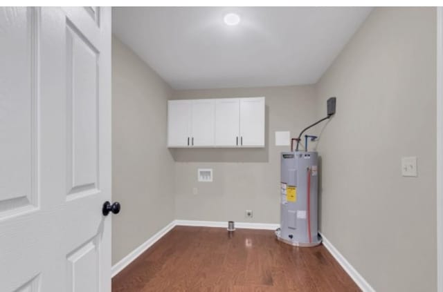 clothes washing area with hookup for a washing machine, water heater, dark wood-type flooring, hookup for an electric dryer, and baseboards