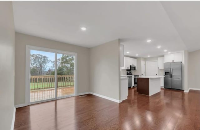 unfurnished living room featuring recessed lighting, dark wood finished floors, and baseboards