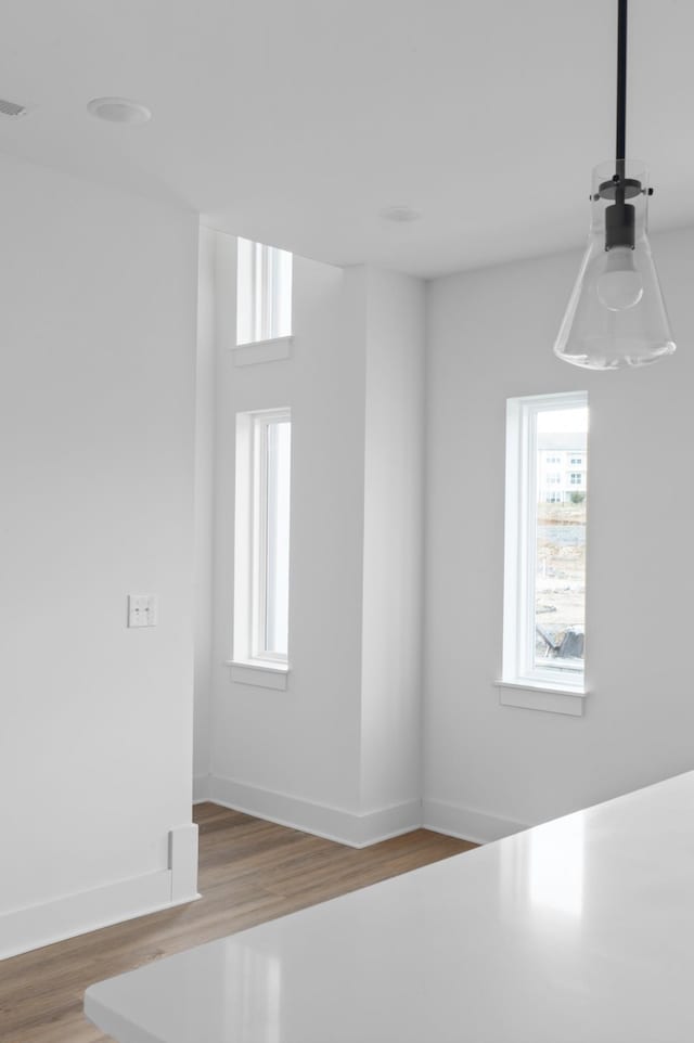 spare room with baseboards and wood finished floors