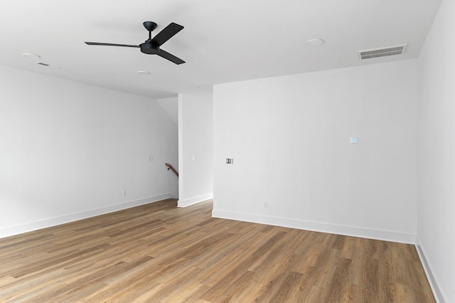 unfurnished room featuring ceiling fan, light wood-type flooring, visible vents, and baseboards