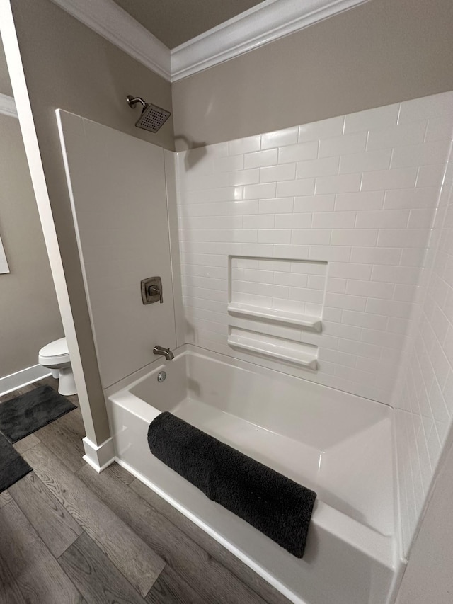 bathroom with shower / bathing tub combination, toilet, wood finished floors, and ornamental molding