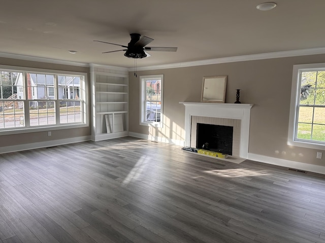 unfurnished living room with a fireplace with flush hearth, wood finished floors, visible vents, and ornamental molding