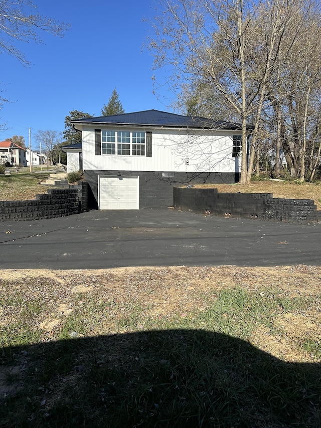 view of front of house featuring an attached garage and metal roof