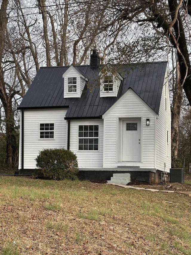 view of front of house featuring entry steps, a chimney, and metal roof