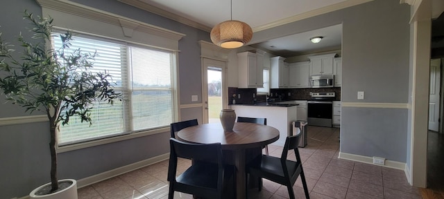 dining space with tile patterned flooring, ornamental molding, and baseboards