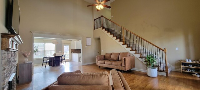 living area featuring stairs, baseboards, and wood finished floors