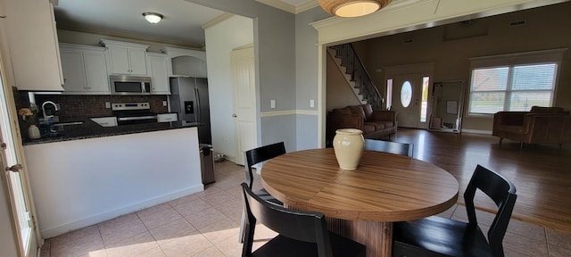 dining room featuring baseboards, visible vents, stairs, crown molding, and light tile patterned flooring